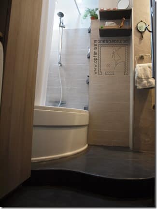 Petite salle de bain avec baignoire sur estrade en béton ciré